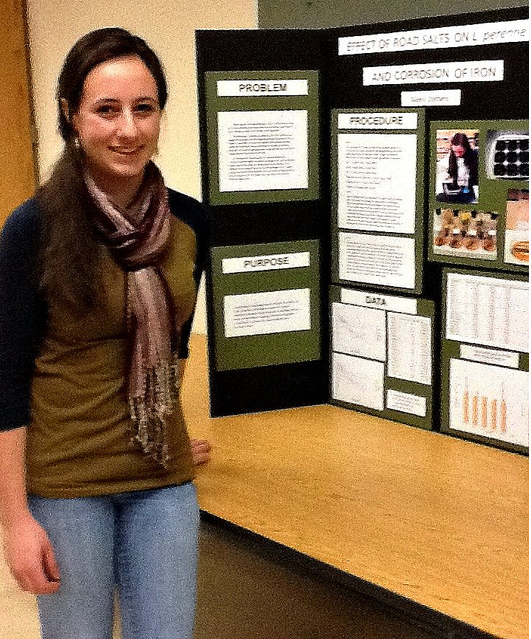 Alexis Stefano stands in front of her 1st prize science fair project entitled The Effects of Road Salts on L. Perenne and Corrosion of Iron. Photo by Blair Guild