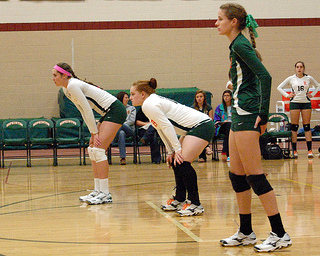 In a previous game against Medfield, Senior Volleyball Captains, (left to right) Tess Chandler, Lindsay Manning, and Kristen Cooprider, anticipate the next play  on October 12th, 2012. Photo by Elizabeth Clark
