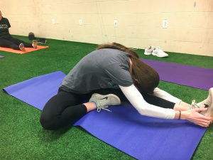 Photo: Halloran is stretching in the fit lab, located in the Hopkinon High school