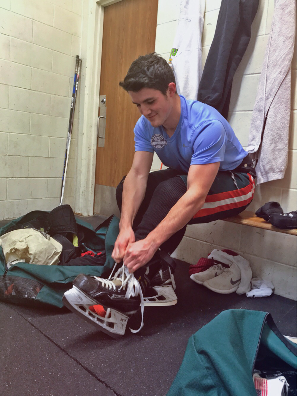 Photo: Owen Delaney lacing up his skates before practice. Photo by Hunter Temple.