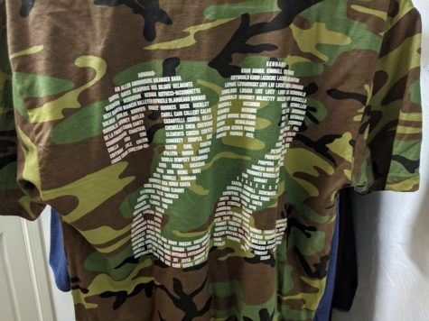 The Class of 2022 Hillers Camo shirt hanging from a hanger in a closet.