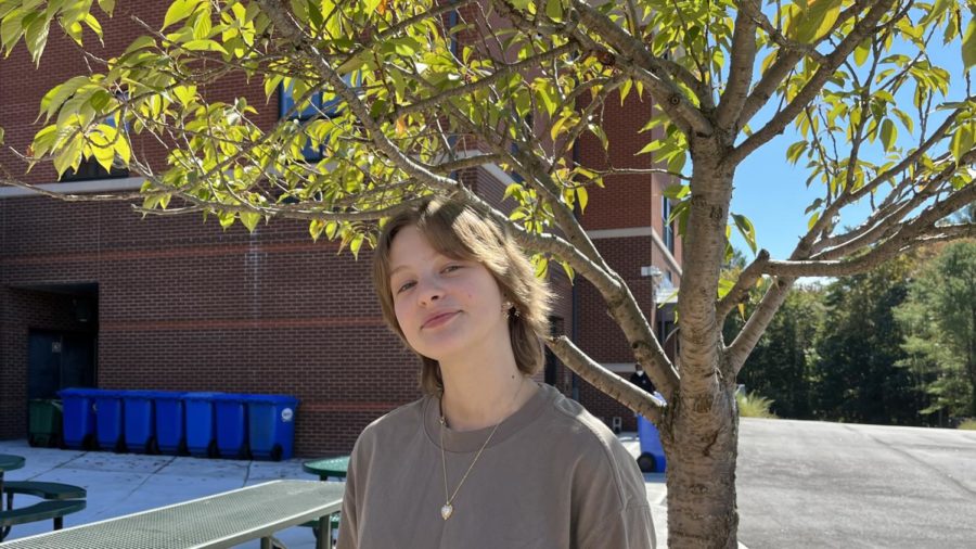 Photo: Its easy being green. Alice Potapov poses for a headshot in her favorite part of the school, the outdoor courtyard. She’s enjoying her first term as part of the Sustainable Green Committee. “Its really cool to connect with people that have similar interests,” Potapov said.