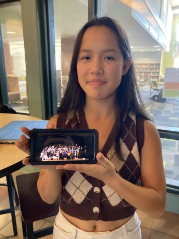 Grace Losada holding a picture of last year's Showcase