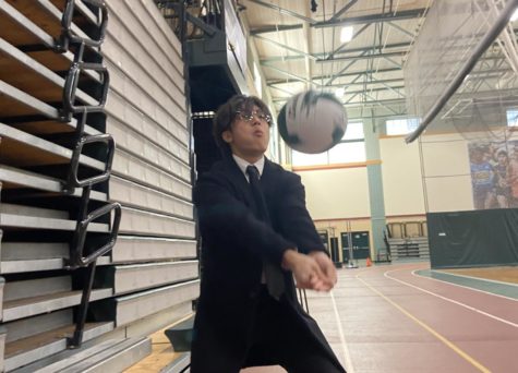 Photo: Solomon Jun sets volleyball in the gymnasium
