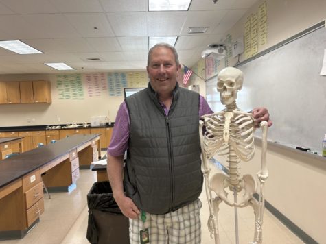 King poses with Fred the skeleton in his classroom. 