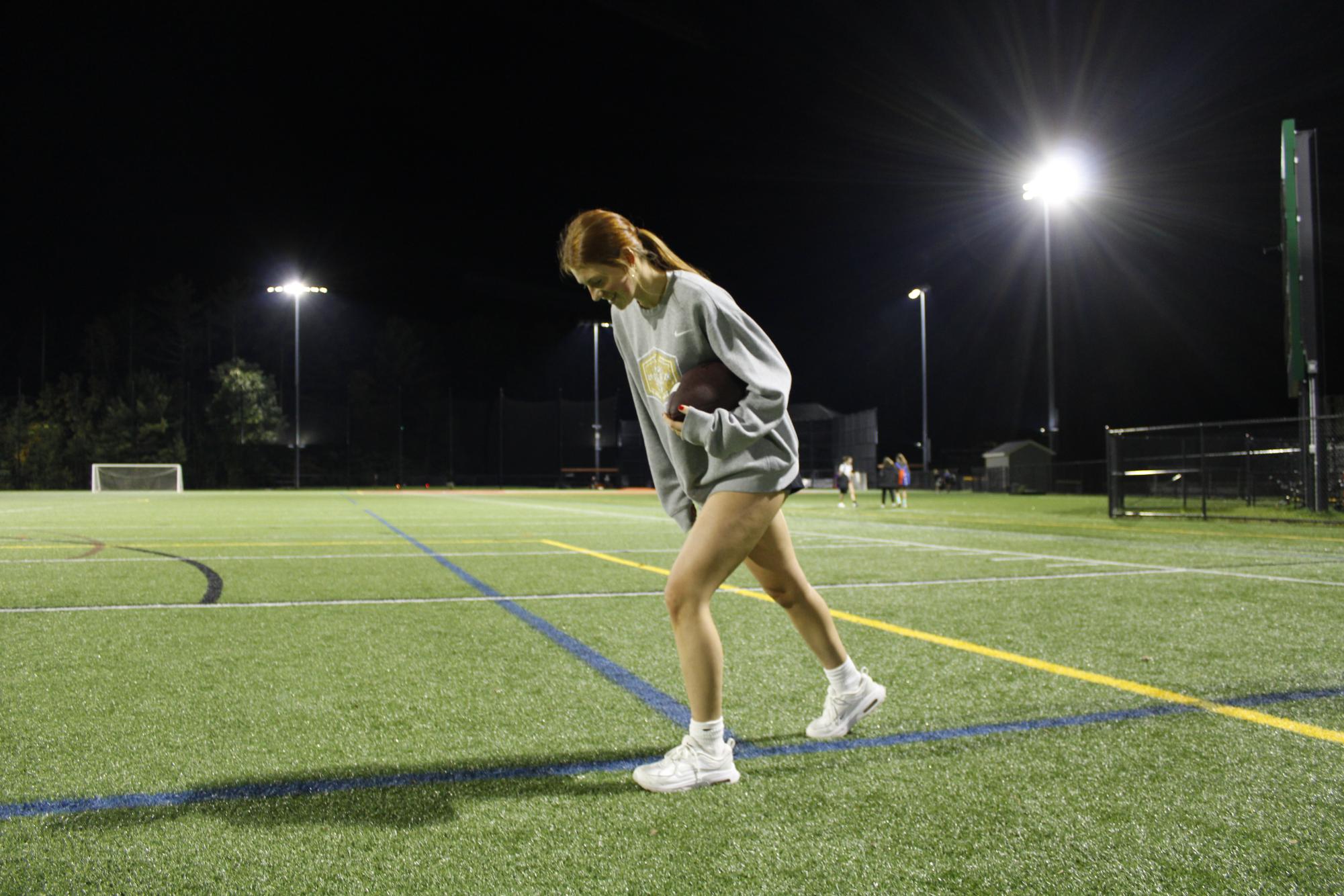 Senior wide receiver Johanna DuPont runs plays under the lights in preparation for the game.