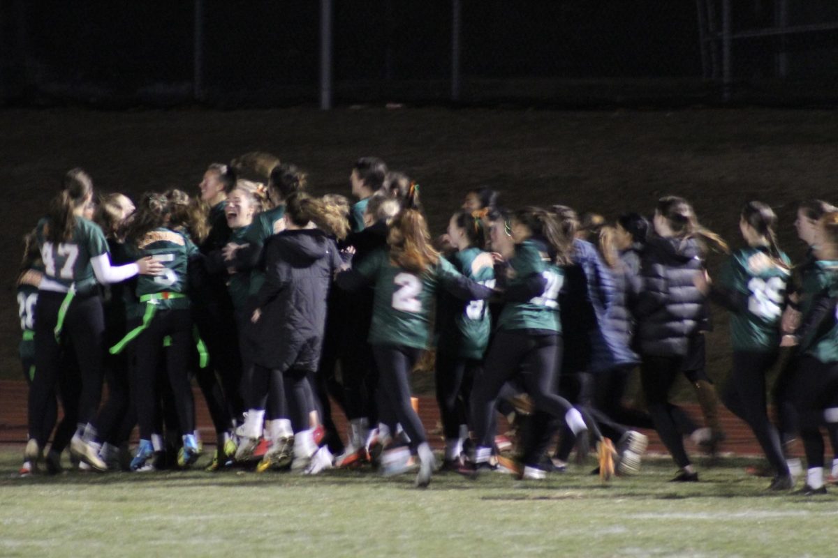 Senior girls charge the field after getting their winning touchdown. This photo shows the team excitement and unity, as seen the previous year.