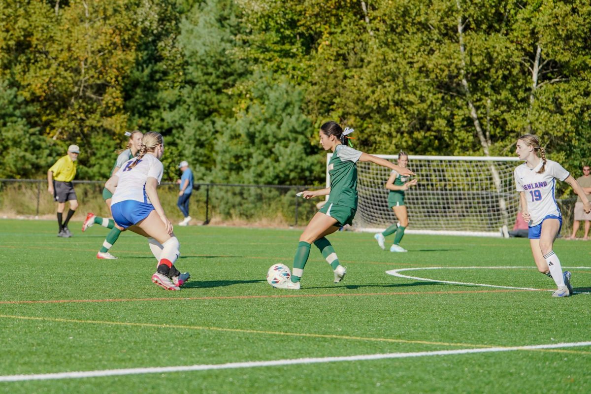 Freshman Nina Clement looks to pass the ball to a teammate.  “Every game is going to be a tough game. That’s kind of the nature of our league when it comes to girls soccer,” Coach Dan Collins said.